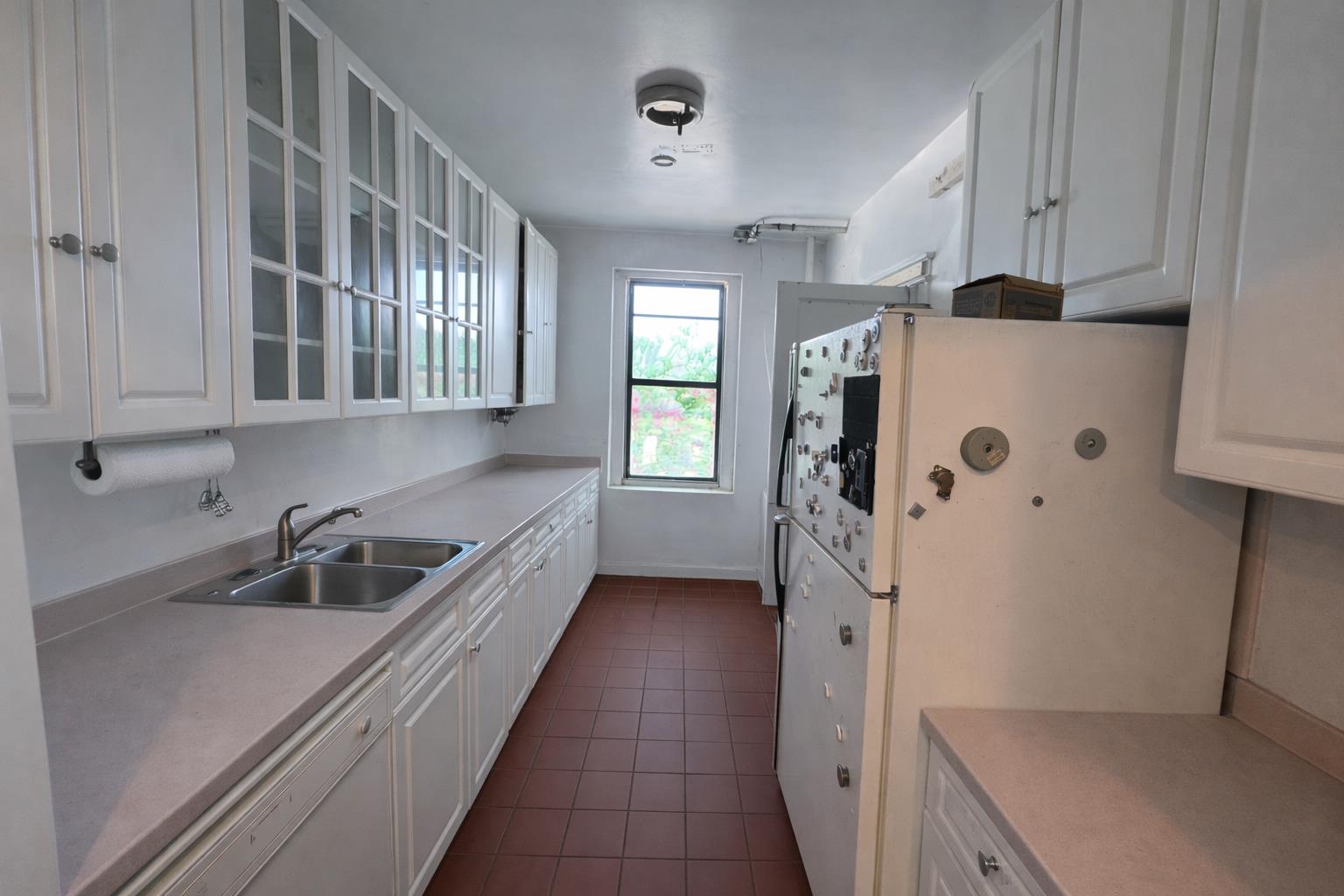 1825 Riverside Drive, Unit 5B Manhattan, NY 10034 - Photo 4 of 19 a kitchen with window and cabinets