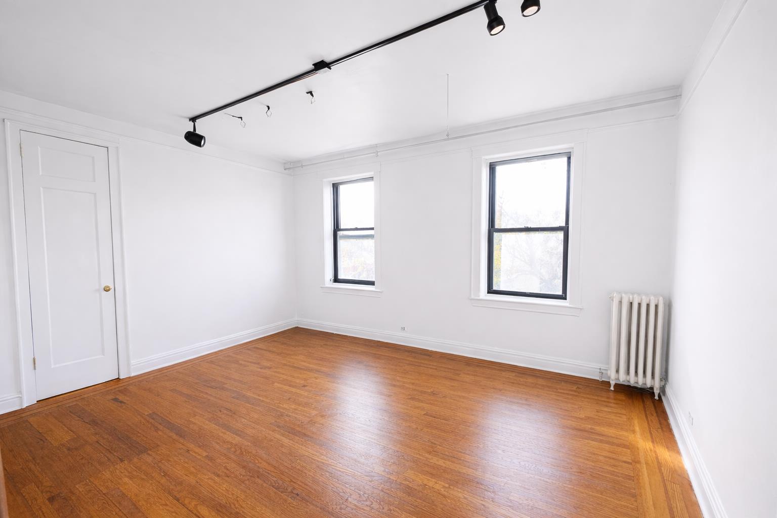 1825 Riverside Drive, Unit 5B Manhattan, NY 10034 - Photo 8 of 19 a view of an empty room with a window and wooden floor