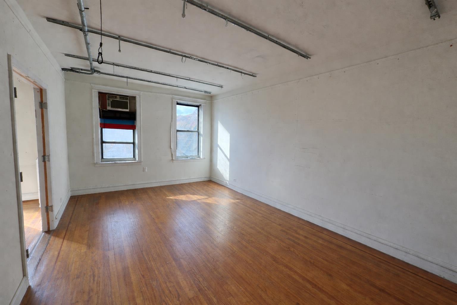 1825 Riverside Drive, Unit 5B Manhattan, NY 10034 - Photo 9 of 19 wooden floor in an empty room with a window
