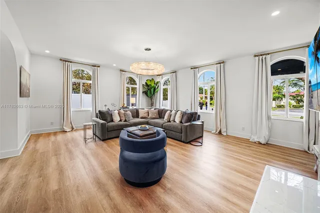 a kitchen with stainless steel appliances white cabinets sink and wooden floor