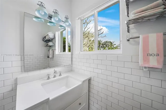 a view of a white house with a large trees