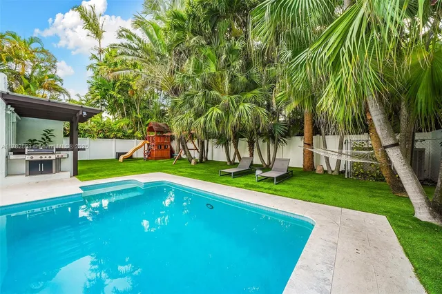 a view of a patio with table and chairs potted plants and palm tree