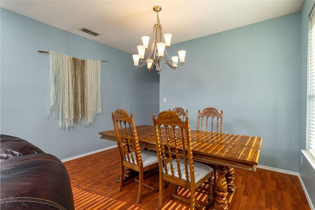 4025 Chisos Rim Trail Fort Worth, TX 76244 - Photo 8 of 40 Dining area featuring wood-finish flooring, light blue wall paint, and a multi-arm chandelier