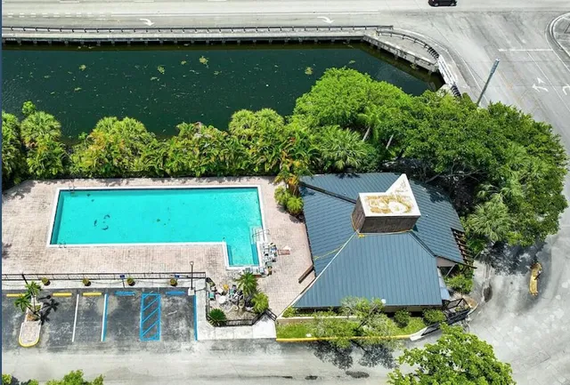 an aerial view of a house with a garden and lake view