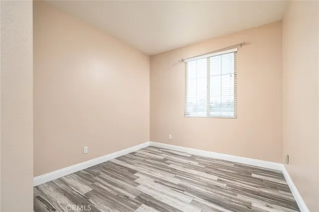 a view of a room with wooden floor and a window