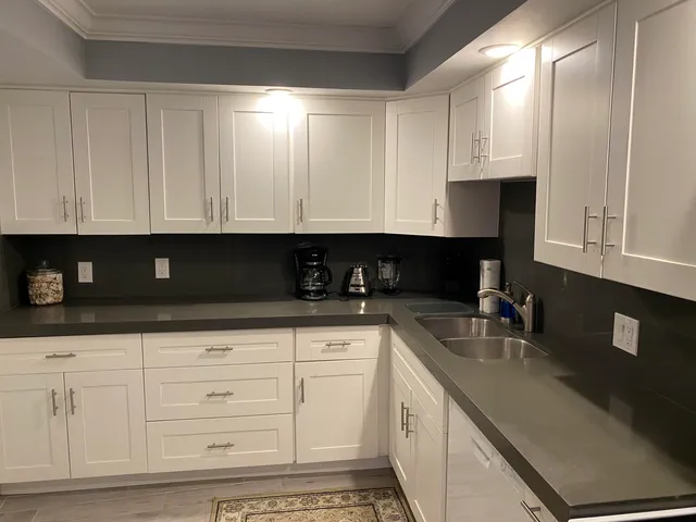 a kitchen with white cabinets and sink
