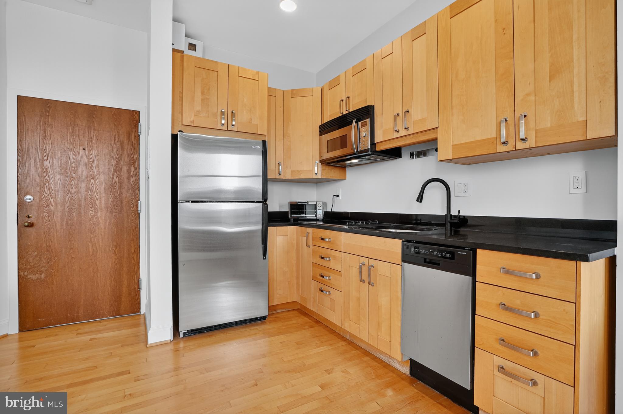 1615 Q Street Northwest, Unit 601 Washington, DC 20009 - Photo 9 of 19 a kitchen with stainless steel appliances granite countertop a refrigerator sink and cabinets