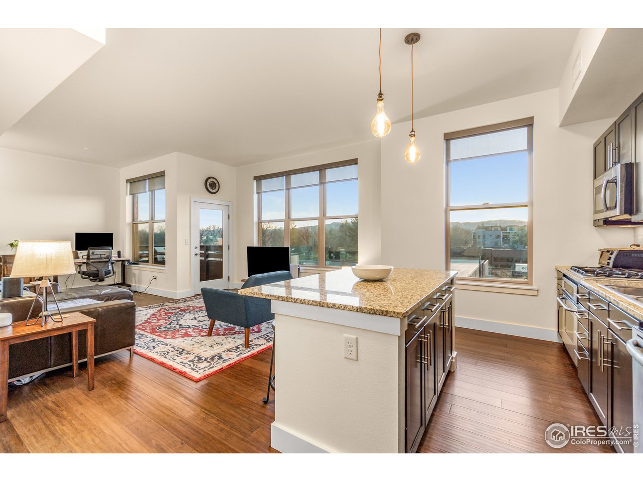 204 Maple Street, Unit 301 Fort Collins, CO 80521 - Photo 1 of 26 a living room with stainless steel appliances kitchen island granite countertop furniture a rug a fireplace and a open kitchen view