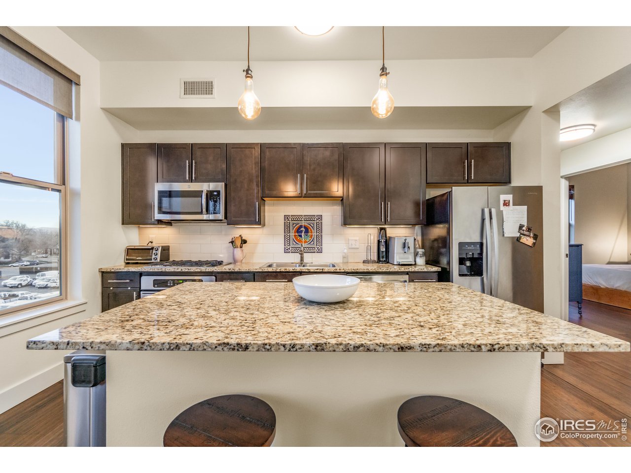 204 Maple Street, Unit 301 Fort Collins, CO 80521 - Photo 8 of 26 a kitchen with kitchen island granite countertop a sink stove and refrigerator