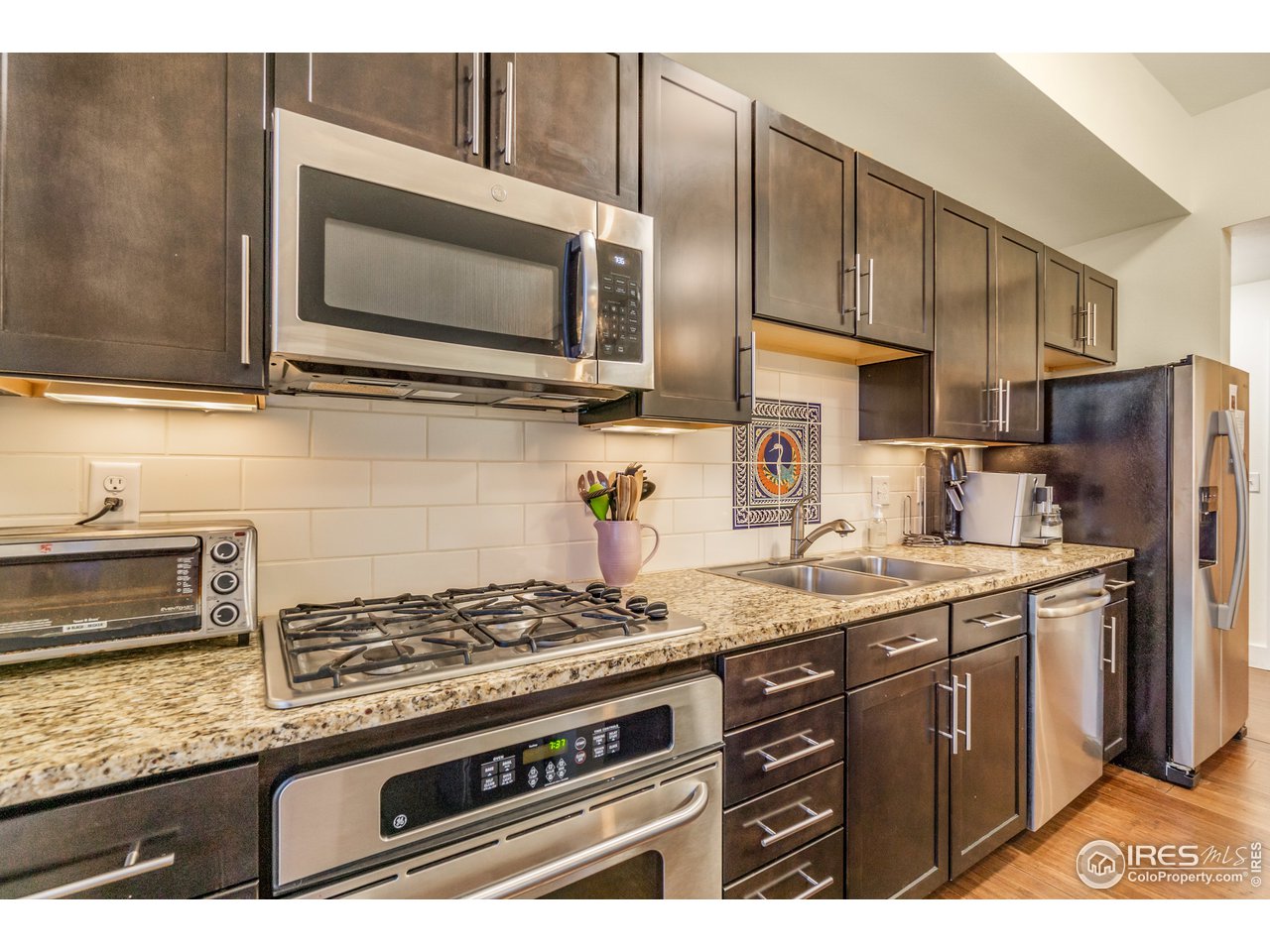 204 Maple Street, Unit 301 Fort Collins, CO 80521 - Photo 10 of 26 a kitchen with stainless steel appliances granite countertop a sink stove and microwave