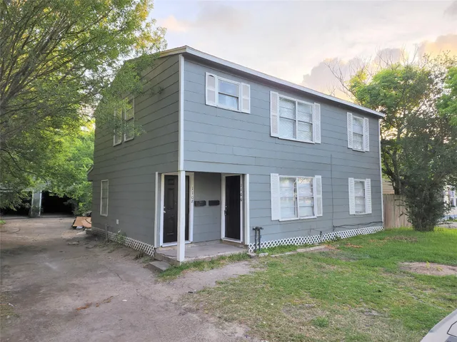 a front view of a house with a garden and yard