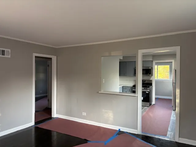 wooden floor in an empty room with a kitchen