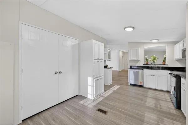 a kitchen with white cabinets and white appliances