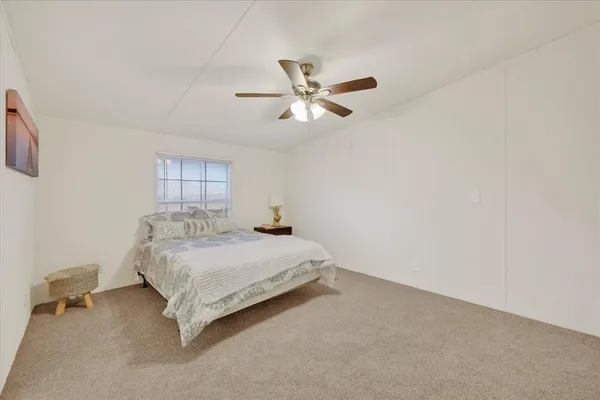 a spacious bedroom with a bed and a chandelier