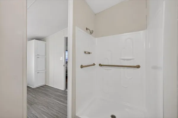 a spacious bathroom with a granite countertop sink a toilet mirror and bathtub