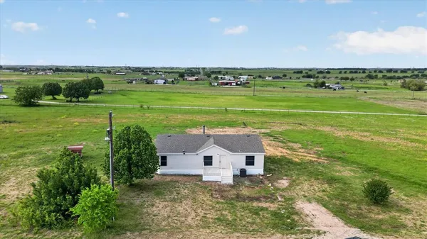 an aerial view of a house with big yard