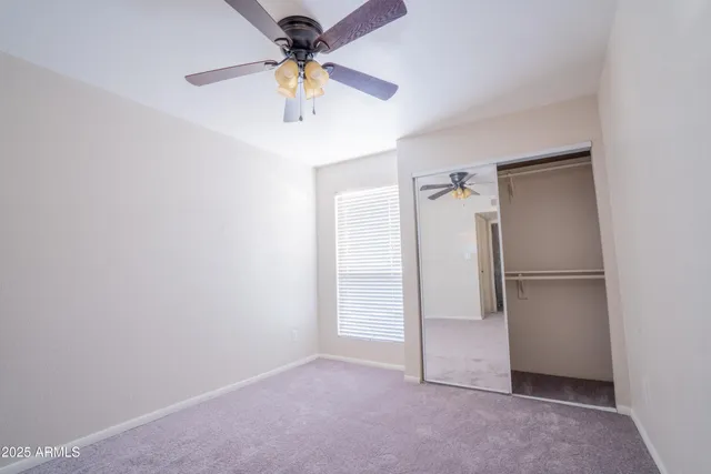 an empty room with a ceiling fan and a fan