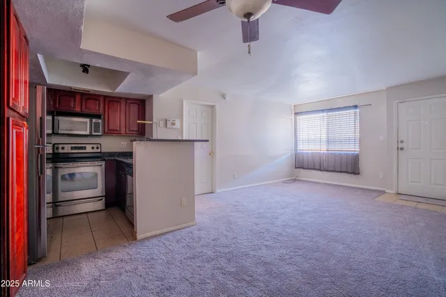 a view of kitchen with refrigerator cabinets and stove top oven