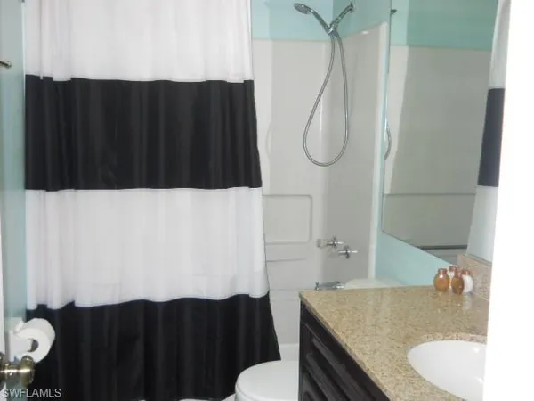 a bathroom with a sink vanity mirror and toilet