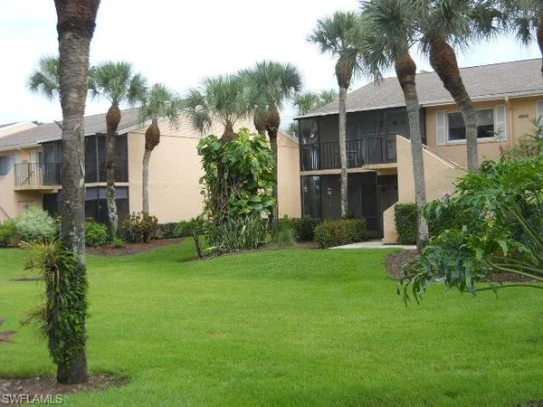 a view of a house with a yard and potted plants
