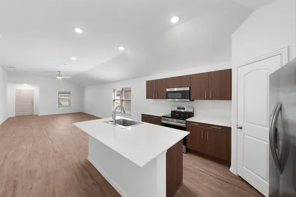a kitchen with stainless steel appliances a sink stove and refrigerator