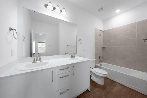 a bathroom with a double vanity sink mirror double and bathtub