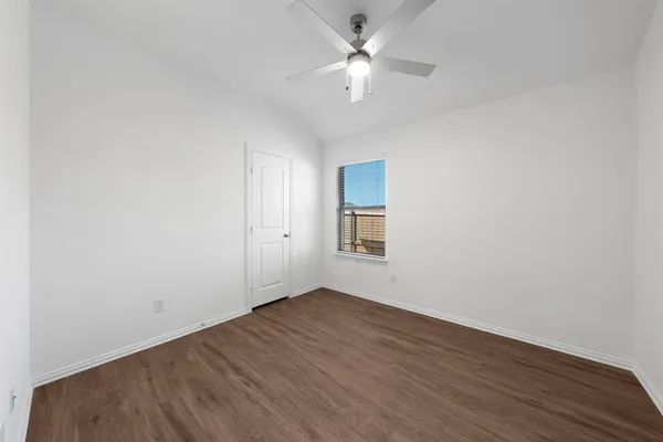 an empty room with a window and a ceiling fan