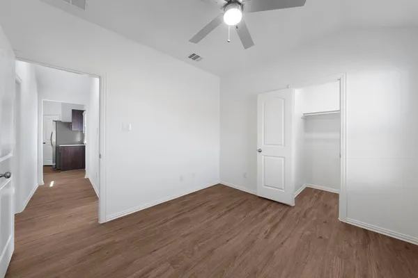 wooden floor in an empty room with a bathroom