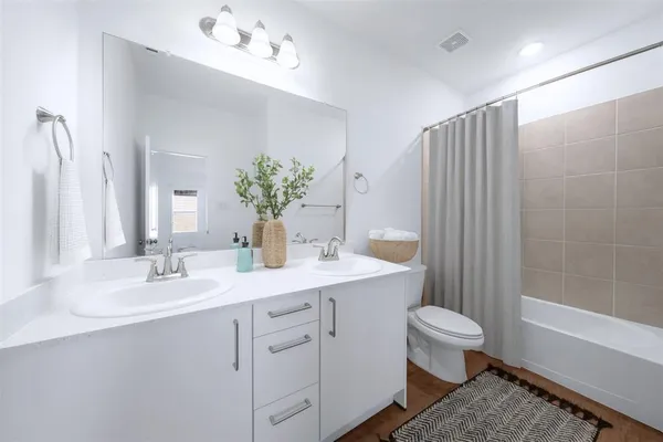 a bathroom with a granite countertop sink a toilet and a mirror