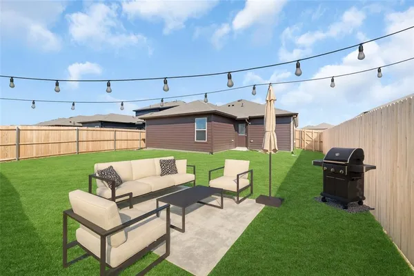 a view of a patio with couches chairs potted plants and a yard