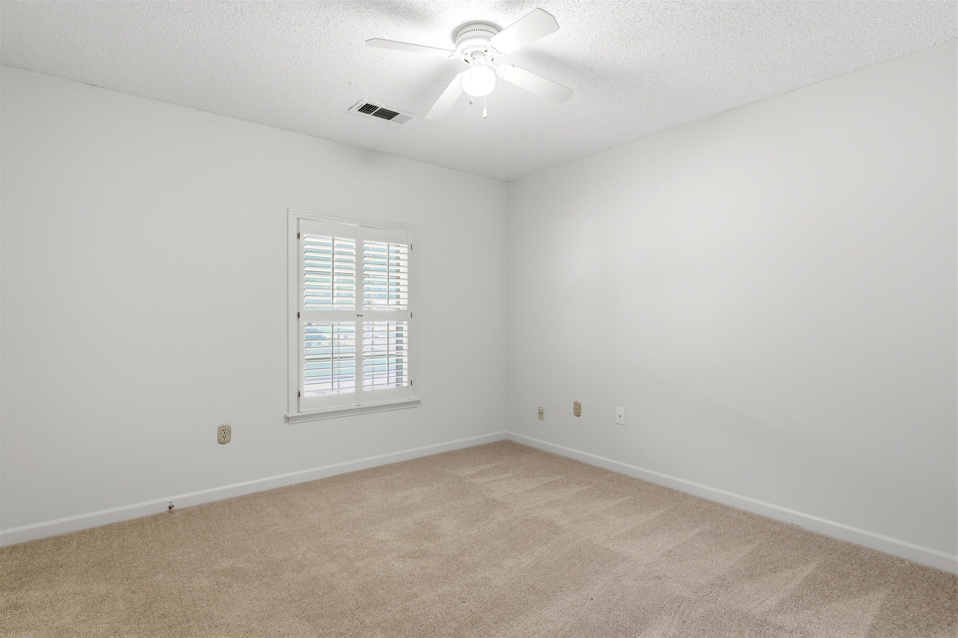 1984 Allenby Road Germantown, TN 38139 - Photo 33 of 37 Neutral wall paint complementing textured carpeting, a white window frame with louvered blinds, and a white ceiling fan with integrated lighting