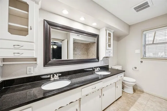 a bathroom with a granite countertop double vanity sink and a mirror