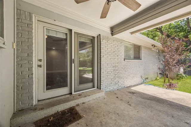a view of a brick house with a large window and wooden walls