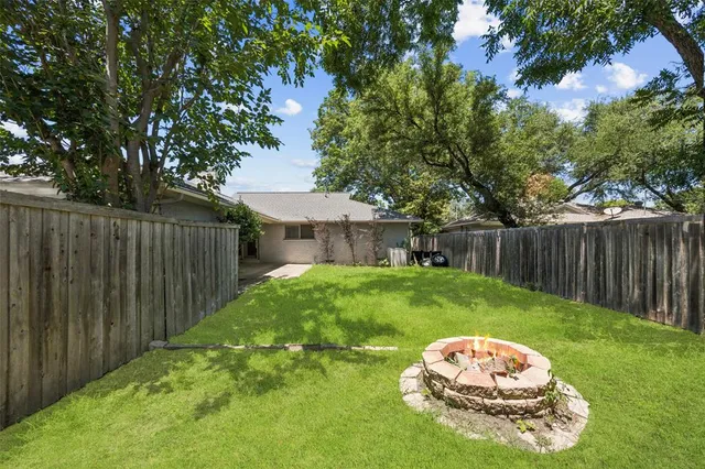 a view of a backyard with table and chairs and wooden fence