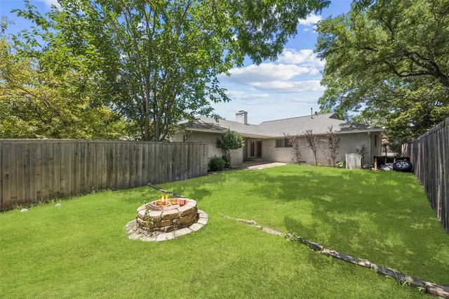 a backyard of a house with table and chairs