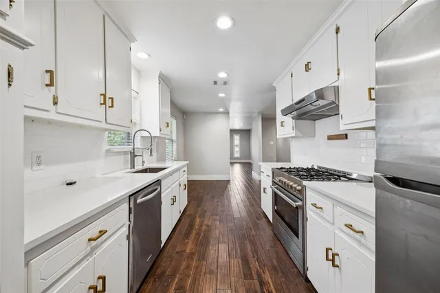 a kitchen with stainless steel appliances granite countertop a sink stove and refrigerator