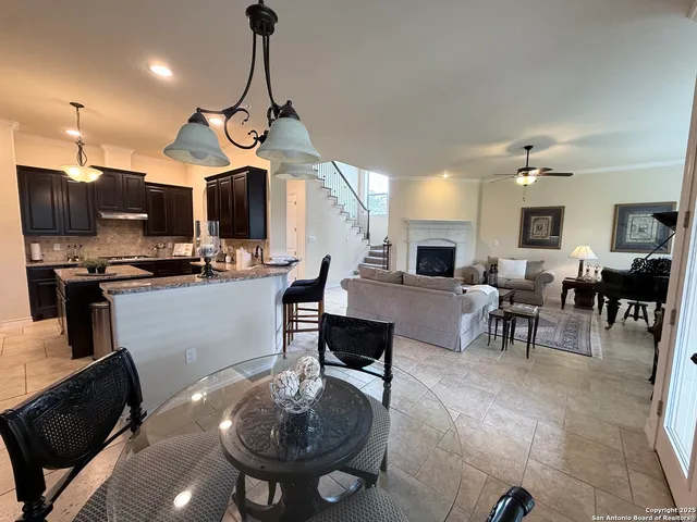a dining room with stainless steel appliances furniture a rug and a view of kitchen