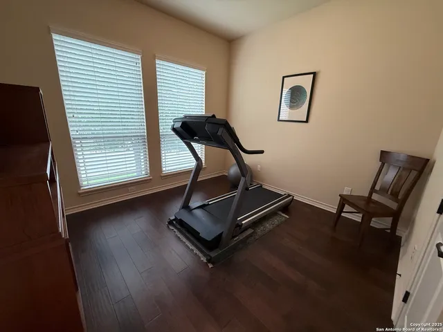 a view of a workspace with furniture and a window