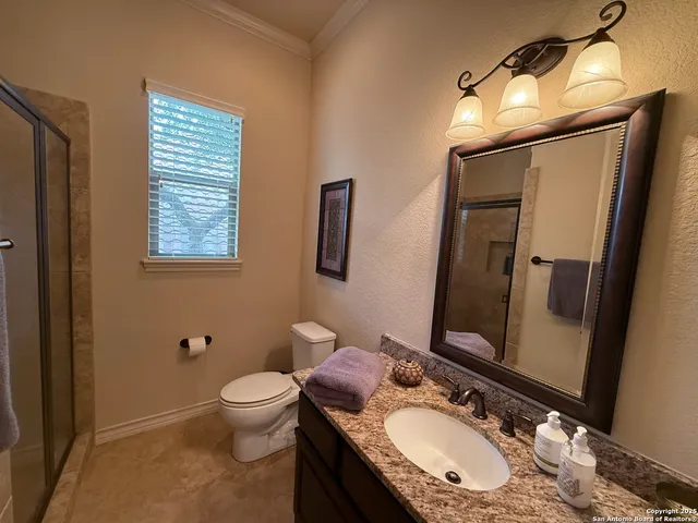 a bathroom with a granite countertop sink toilet a mirror a vanity and shower