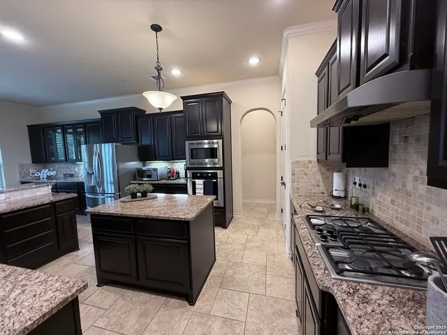 a kitchen with granite countertop stainless steel appliances and a counter space