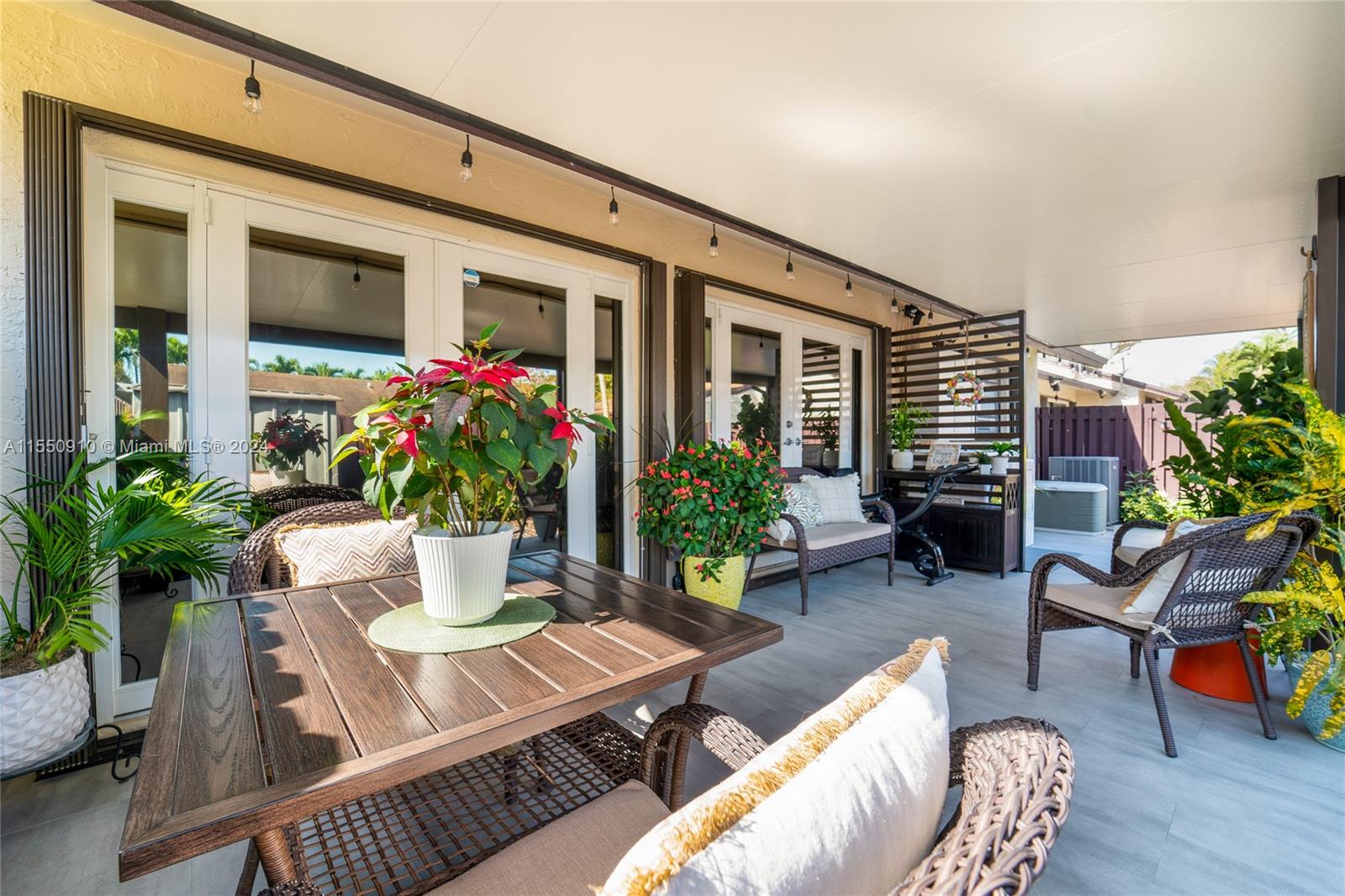 11310 Southwest 115th Terrace, Unit 11310 Miami, FL 33176 - Photo 11 of 13 a view of a patio with couches table and chairs and potted plants