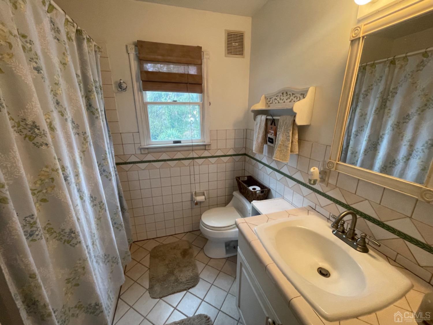 22 Wilcox Road New Brunswick, NJ 08901 - Photo 6 of 12 a bathroom with a sink a toilet and a mirror