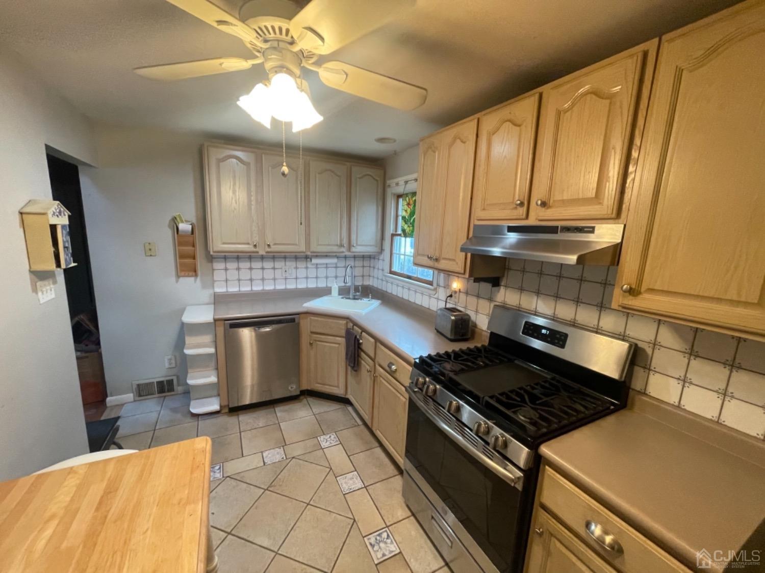 22 Wilcox Road New Brunswick, NJ 08901 - Photo 7 of 12 a kitchen with a stove a sink and a refrigerator