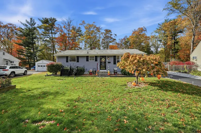 a front view of a house with a yard table and trees