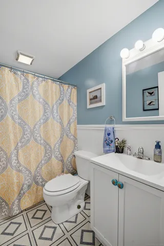a bathroom with a sink a toilet and shower curtain