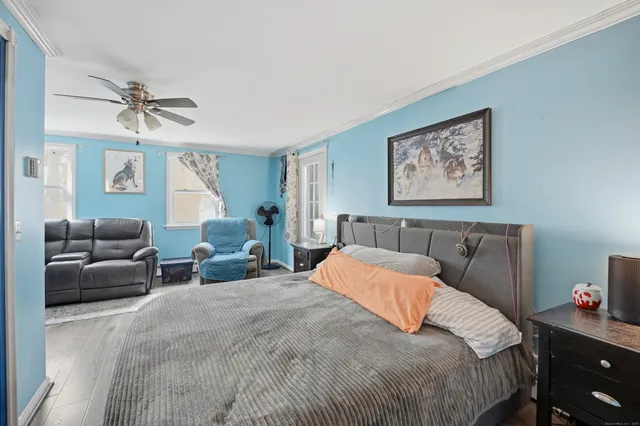 a bedroom with a bed a couch and potted plant