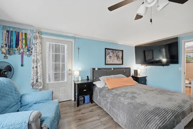 a bedroom with a large bed a flat screen tv and dresser