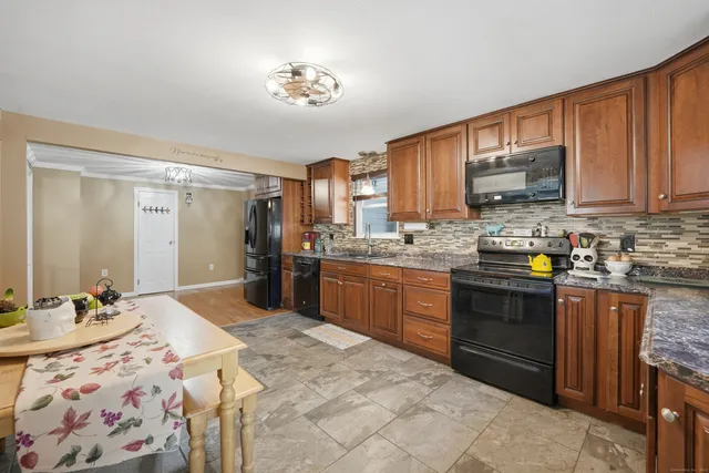 a kitchen with stainless steel appliances granite countertop a sink dishwasher stove top oven and cabinets with wooden floor