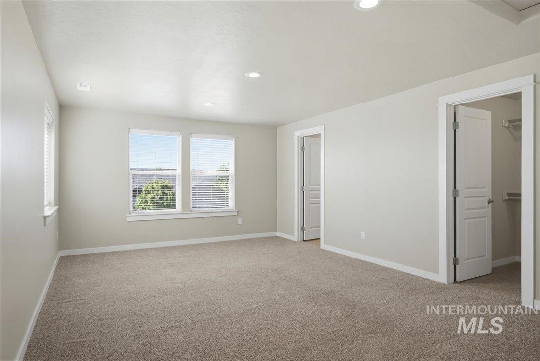 12460 West Azure Street Boise, ID 83713 - Photo 27 of 34 Spacious room with plush carpet flooring, recessed lighting, white trim, and multiple windows with blinds