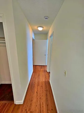 a view of a hallway with wooden floor and staircase